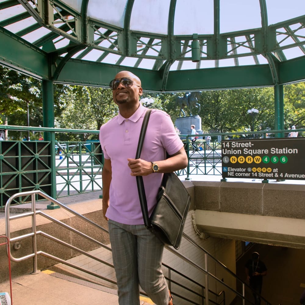 An African American man walks up the stairs of the Union Square subway stop.